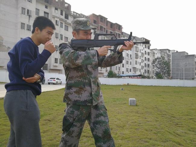 赣州军分区政委陈庆阳指导辜梓豪射击训练