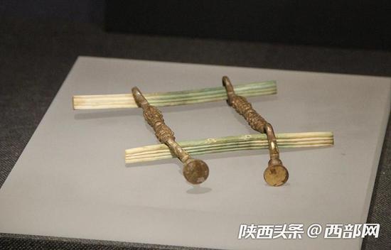 鎏金铜马衔,下方泛绿色骨镳为象牙制品。