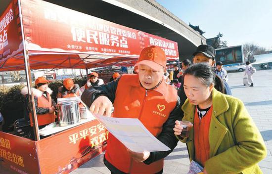 志愿者在西安火车站广场为旅客指路