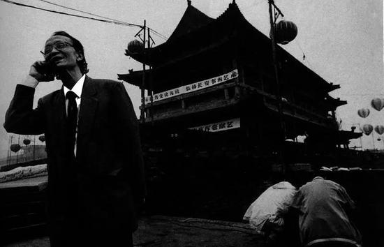 1996年,西安城墙上手持“大哥大”的市民。 邱晓明摄