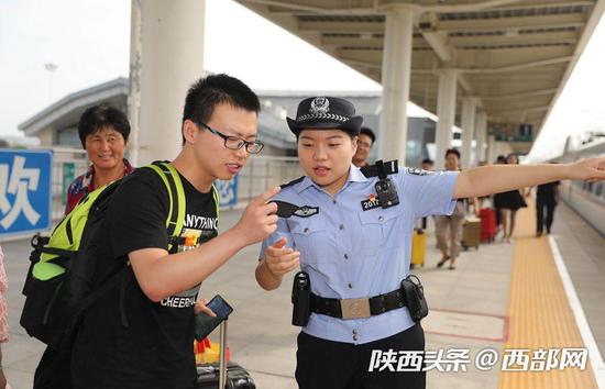 乘警郭婕敏在帮助旅客寻找自己的乘坐车厢