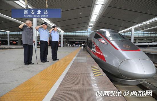 郭婕敏和父亲郭东、爷爷郭来仁一起来到西安北站,向一辆复兴号高铁列车敬礼