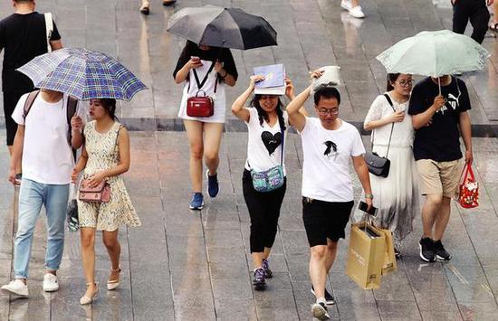 手提袋成了市民临时雨伞 本报记者马昭摄