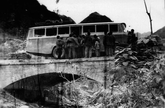 1976年，乘客在白河县茅坪镇龙王沟桥乘坐班车。 安康市交通运输局供图