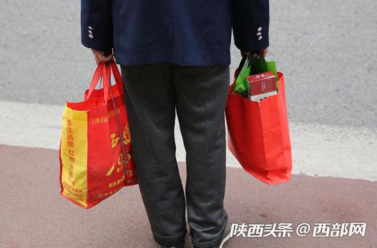 左手2瓶酒,右手一条烟。不过现在很少有人带着烟去拜年了。