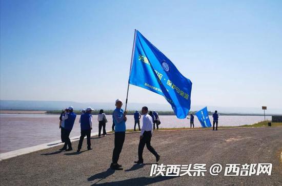 “关爱山川河流保护母亲河”志愿者在黄河岸边巡堤查险、捡拾垃圾。