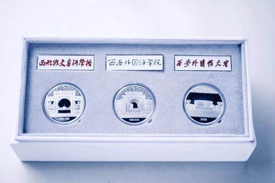 西安外国语大学纪念章和校徽。(图片来源:西安外国语大学微信公众号)