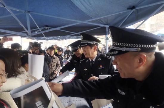 高威副局长向现场群众发放宣传品