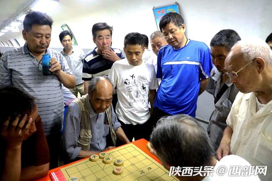 在納涼中心下象棋的老大爺們。