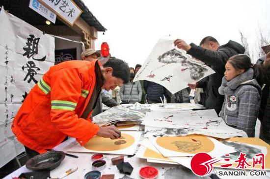 高師傅現(xiàn)場用手指作畫引來圍觀 記者 王曉峰 攝
