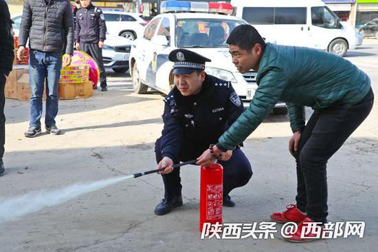 民警检查花炮销售点,并指导销售人员正确使用灭火器。