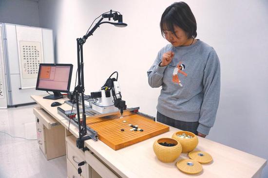 2月20日,西安电子科技大学人工智能学院硕士研究生李艾瑾正在与人工智能棋手进行五子棋对?#20581;?><span class=