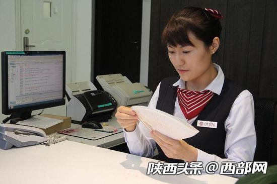 李莉演示扇面点钞方法。