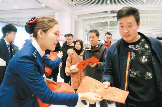 地铁工作人员向乘客发放春联