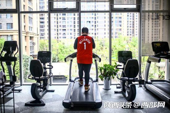 西安部分健身房开始复工,市民戴口罩“撸铁”健身。