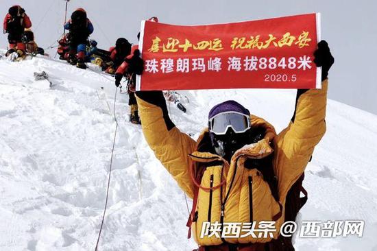 西安登山爱好者白景天在珠峰之巅展示出“喜迎十四运 祝福大西安”标语。