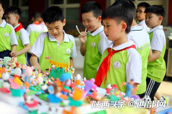 西安建国路小学学生制作手工泥塑十四运会吉祥物。