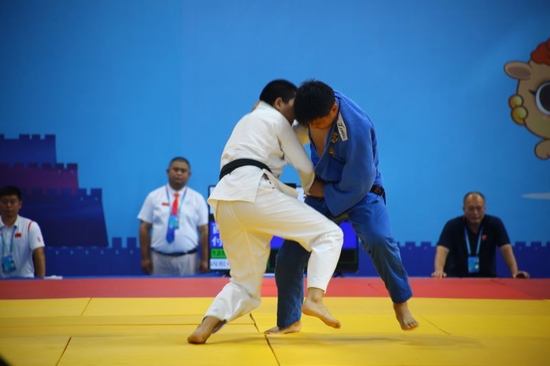 圖為在青少年組柔道男子丙組+57公斤級比賽中，榆林隊王宇杰（白）對戰西安隊孫雨彤（藍） 李志東 攝