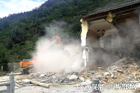 位于喂子坪村北石槽组深山沟里的一栋违建别墅,在破拆机的“铁爪”下轰隆倒塌。