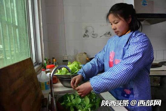 干完农活后，她在家里为一家人做饭。