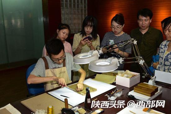 读者观看古籍修复师修复古籍