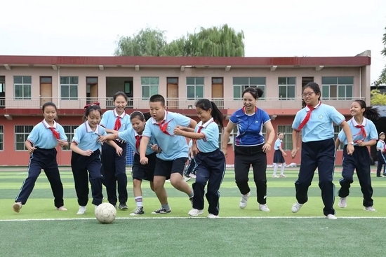 资料图  学生们奔跑在操场中