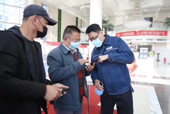 10月25日,黑龙江大庆供电公司员工郑阳为进入办公楼的人员测温登记