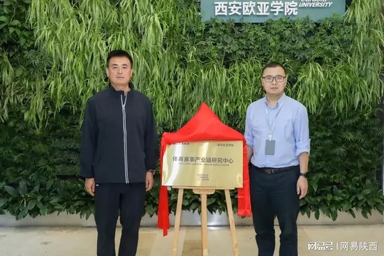 西安曲江体育集团有限公司总经理李总（左）和西安欧亚学院工商管理学院院长吴睿（右）共同为体育赛事产业链研究中心揭牌
