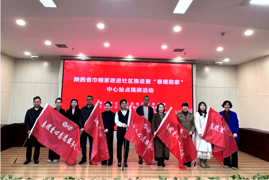 西安培华学院工会主席陈玲（左二）等嘉宾为巾帼家政爱心志愿服务队授旗