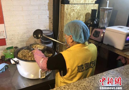 餐厅义工正在打饭。高铖 摄