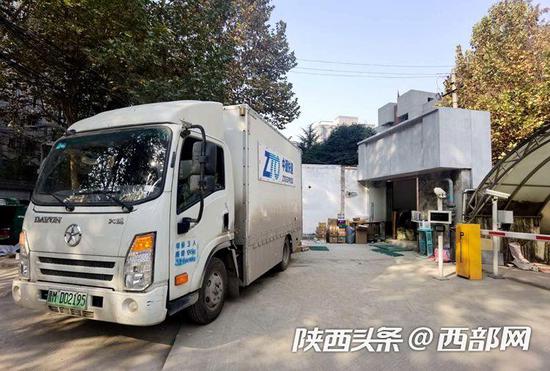 雁塔区农林巷一菜鸟驿站门口,中通快递员正在投递。