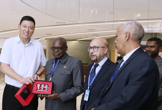 ▲陕旅集团延安公司党委副书记、总经理国小强向驻华外交官一行赠送“金延安IP手办—红宝”