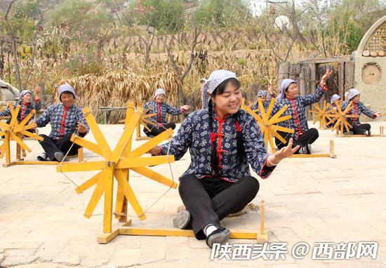 实景剧《高高山上一头牛》中，村里的姑娘们正在纺线。