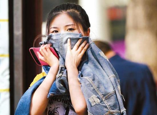 一市民用衣服捂住口鼻防止浮塵 本報(bào)記者馬昭攝