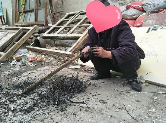 △蹲在地上捡铁丝的老人(实拍)