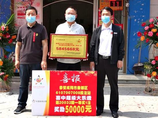 咸阳市体彩管理站站长梁宝光(右一)为出奖彩票店业主颁奖