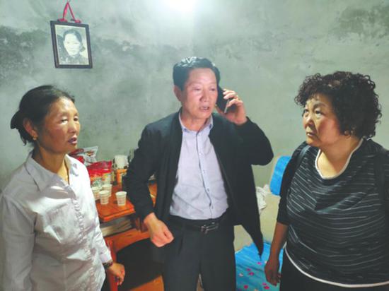 郭西康夫妇在二姐(左一)家,母亲的照片仍挂在墙上。华西都市报 图