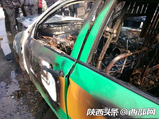 一辆自燃过后的出租车,防劫网依旧牢固。资料图