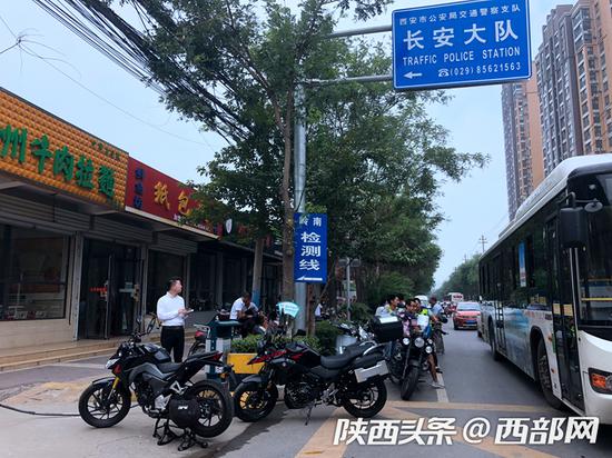 西安市交警支隊(duì)車管所長(zhǎng)安分所門前排隊(duì)等待驗(yàn)車的摩托車及車主。