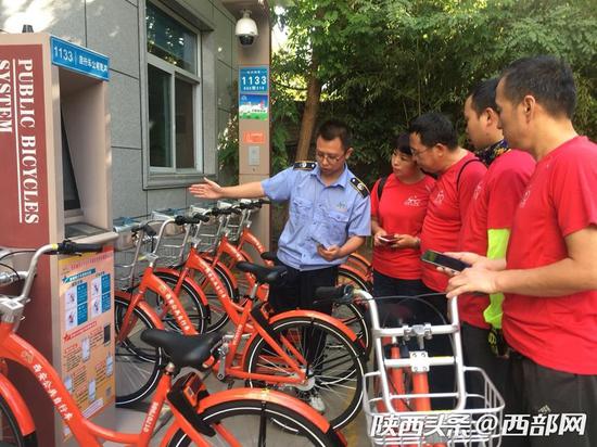 工作人員正在給志愿者講解升級(jí)后公共自行車的用法。資料圖