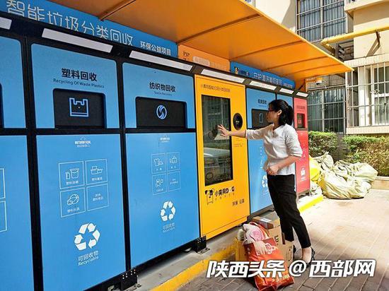 东窑坊小区一位居民在使用智能垃圾箱投放垃圾。