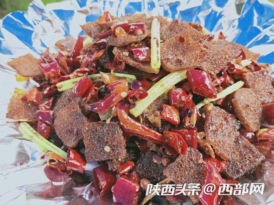 岚皋农家乐业主王三翠在魔芋节展会上给游客展示烹制魔芋炖土鸡技艺。