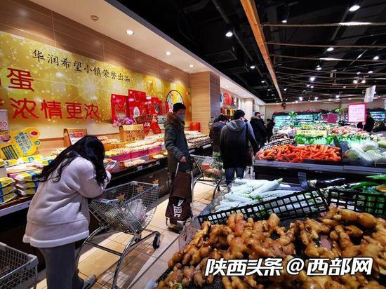 超市内买菜的市民们排起了十几米的长队。