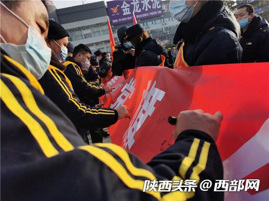 安康火车站职工在为保春运保安全横幅上签名