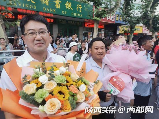 安康中学考点门前,不少爸爸也手捧鲜花,迎接顺利完成考试的孩子。