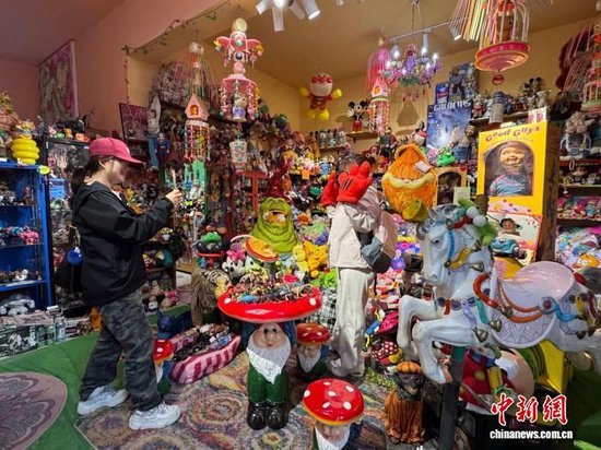 图为张安琪经营的玩具店内，游客正在拍照留念。杨英琦 摄