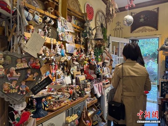 图为游客在黄良新村内开设的一家杂货店参观。杨英琦 摄
