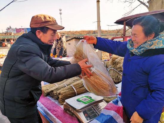 1月22日,王益区黄堡镇年集现场,市民正在选购红薯粉条。
