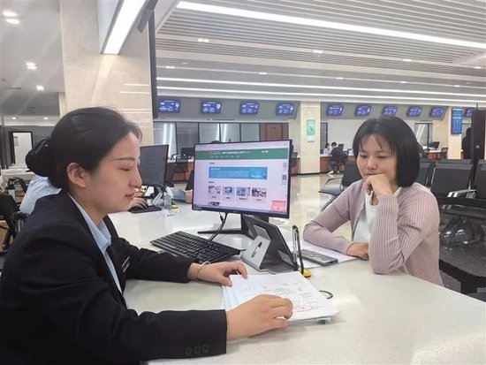 9月27日,杜城村城中村改造安置楼项目综合管理部经理董旭娟(右)在该窗口办理业务。
