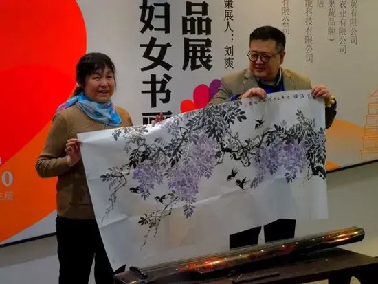 陕西省妇女书画协会副会长周晓燕(左)为启迪TusPark·星商业捐赠作品,郑孟哲总经理接收作品